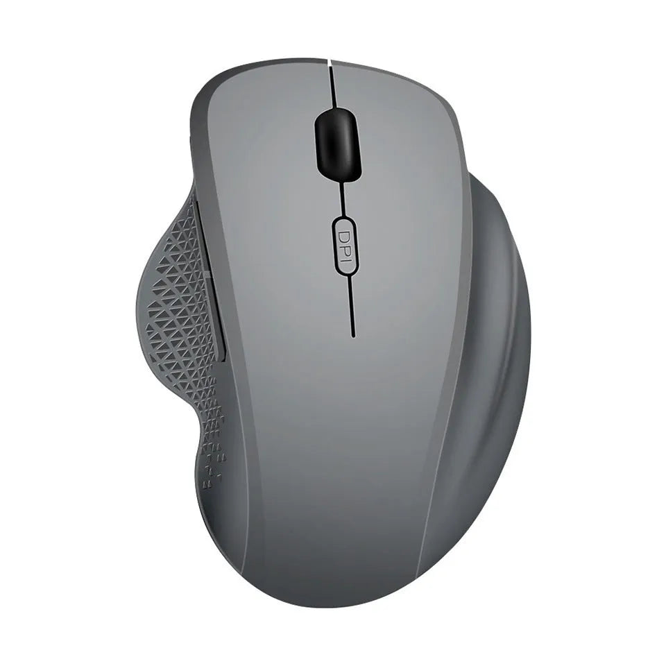 Compact grey wireless mouse with USB charging cable on a wooden desk next to a laptop.
