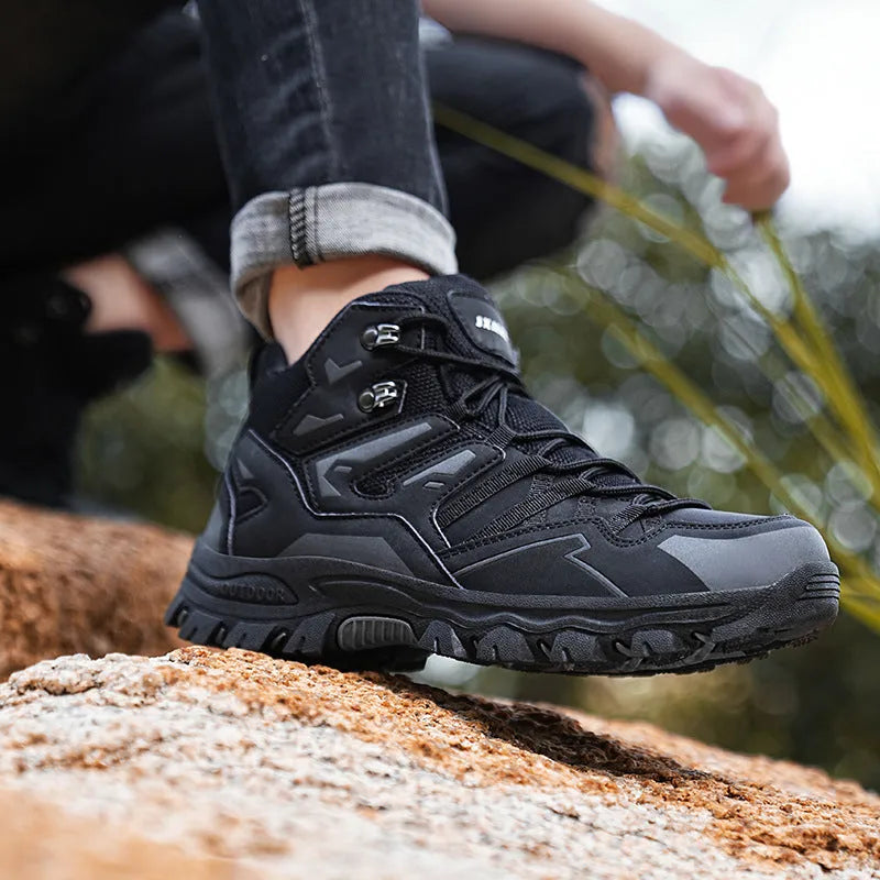 Low-top hiking sneaker in multiple colours on a rocky mountain path, showing lace-up front and rubber sole.