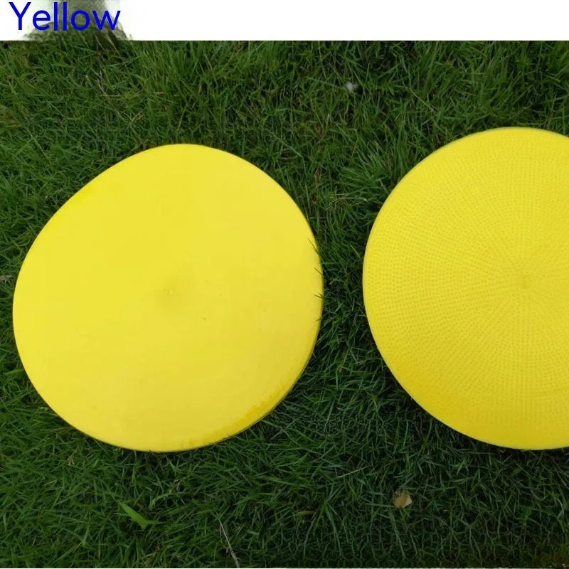 Soft yellow TPE football landmark pad disc on grass, 23 cm diameter.
