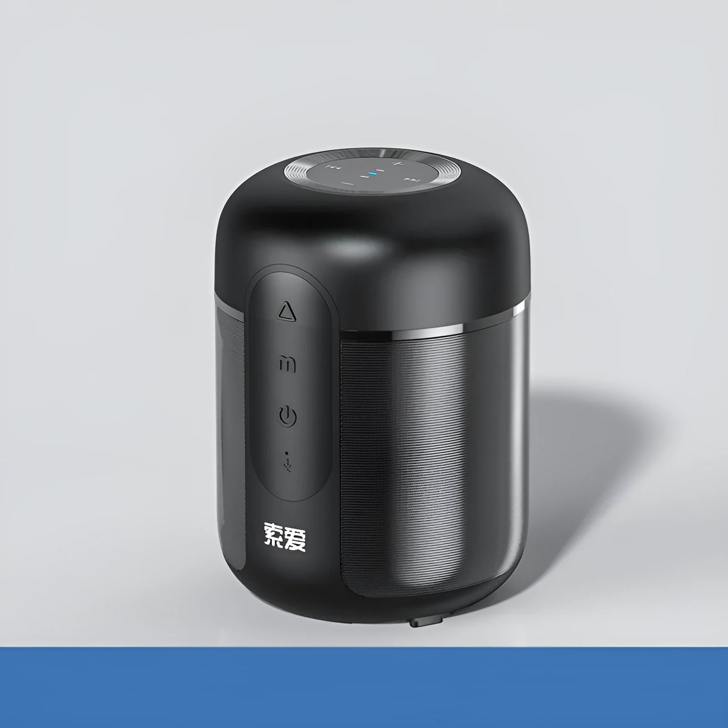 Small black portable Bluetooth speaker showing front grille and control buttons on a table.