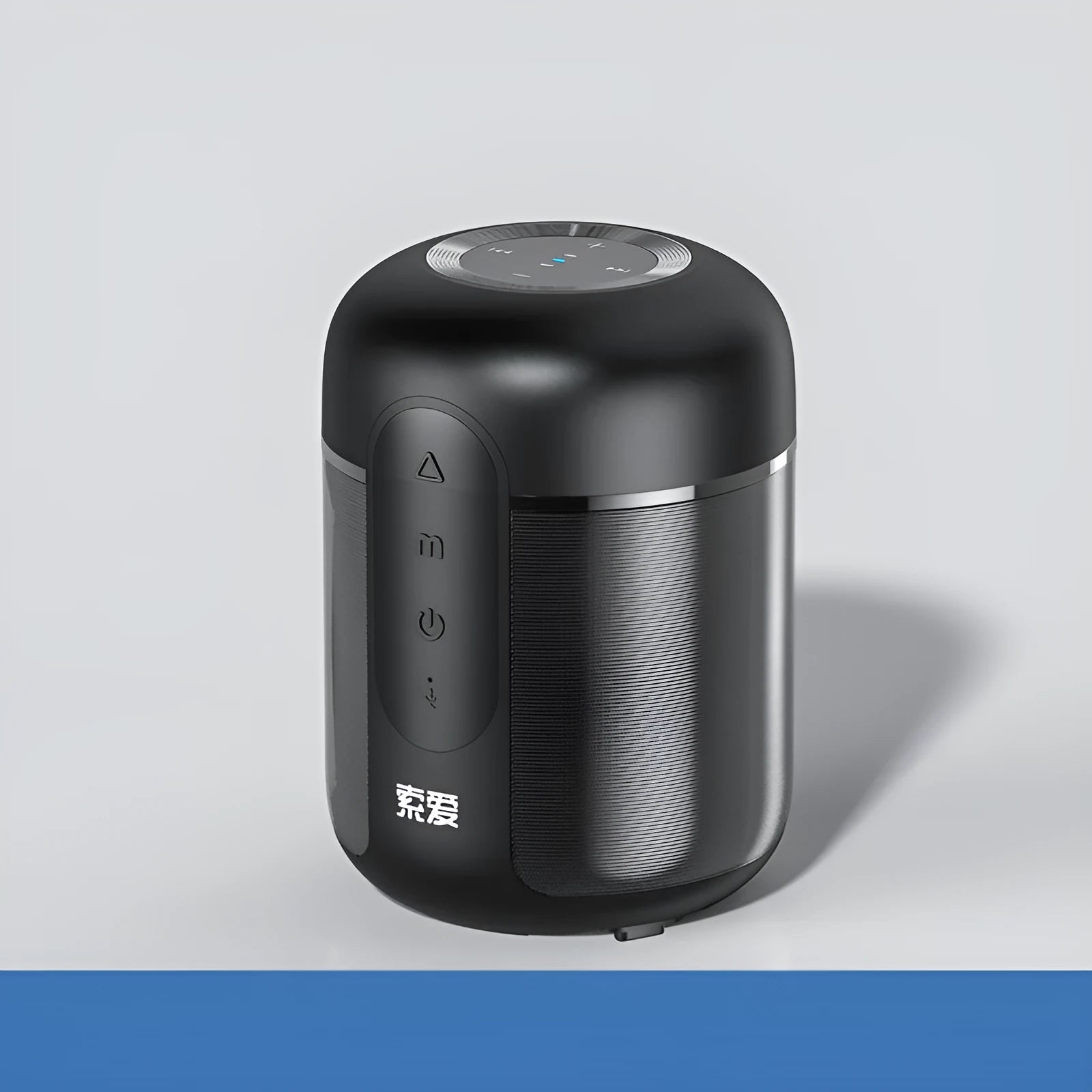 Small black portable Bluetooth speaker showing front grille and control buttons on a table.