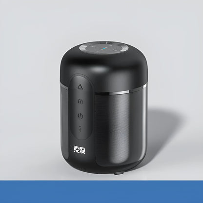 Small black portable Bluetooth speaker showing front grille and control buttons on a table.