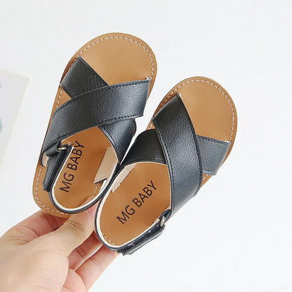 Children's black cross-strap sandals with adjustable Velcro fastening showing size range 21-30