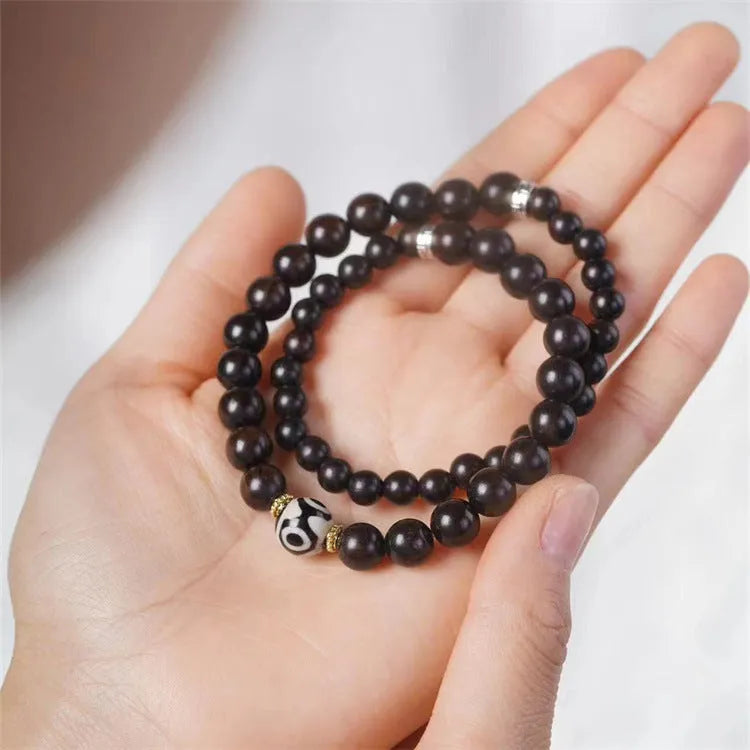 Dark ebony wood bracelet with Tibetan bead design showing two brown circles, 8mm wide unisex accessory