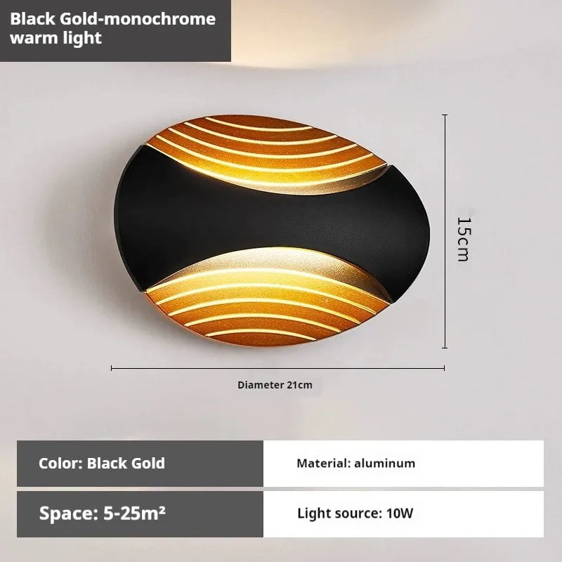 Modern aluminium wall lamp in black finish mounted beside a bed, emitting warm LED light.