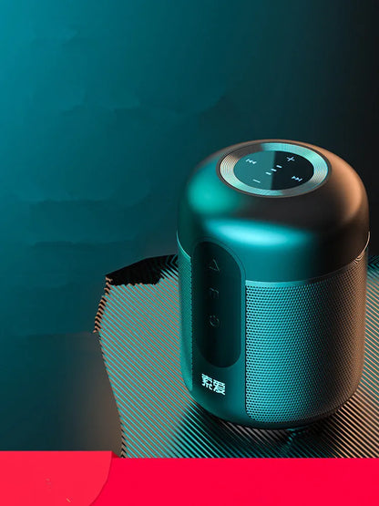 Small black portable Bluetooth speaker showing front grille and control buttons on a table.