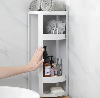 White triangle corner shelf with three tiers mounted in bathroom corner holding toiletries