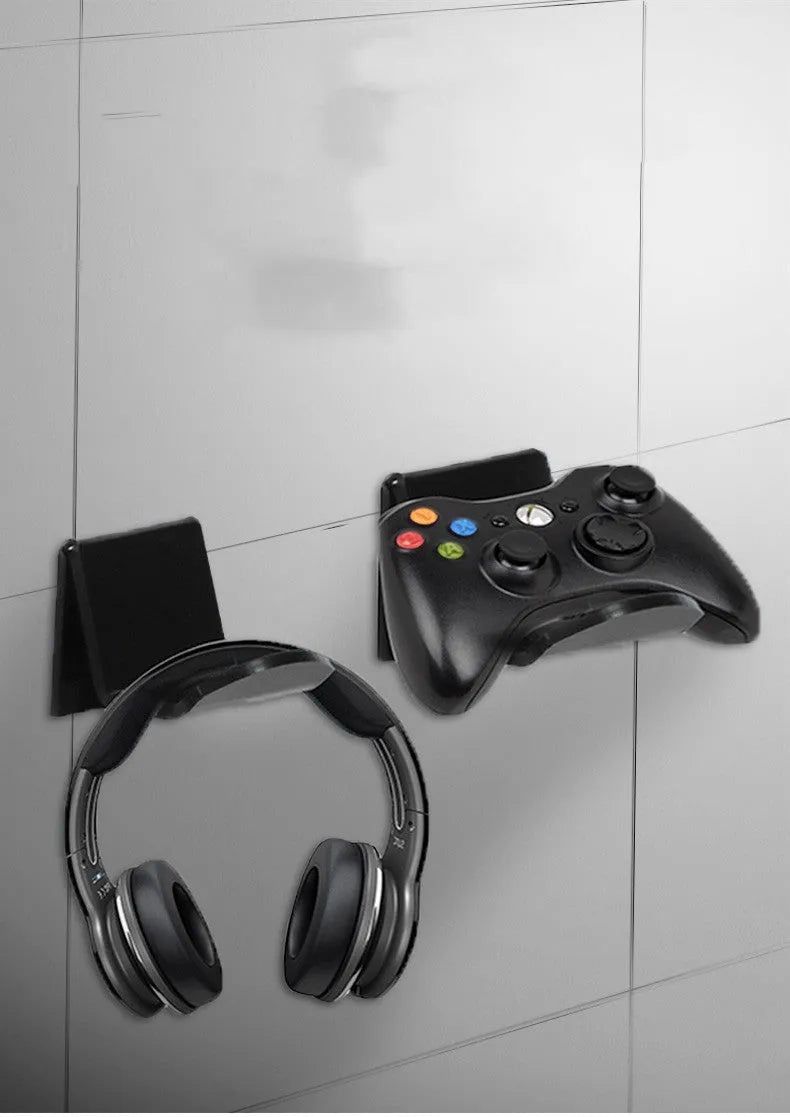 A universal black game controller mounting bracket shown installed on a wall.