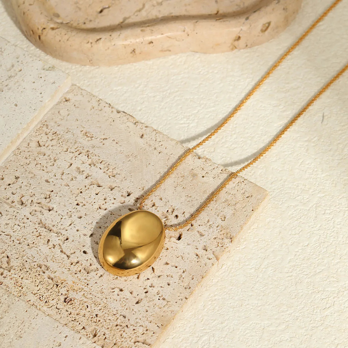 Gold-toned geometric pendant necklace on a chain, showing adjustable length between 41 cm and 50 cm.