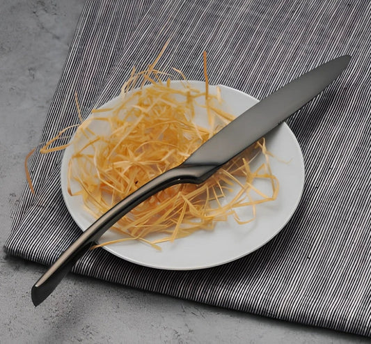 Four-piece black stainless steel cutlery set with mirror polishing showing fork, knife, coffee spoon, and soup spoon