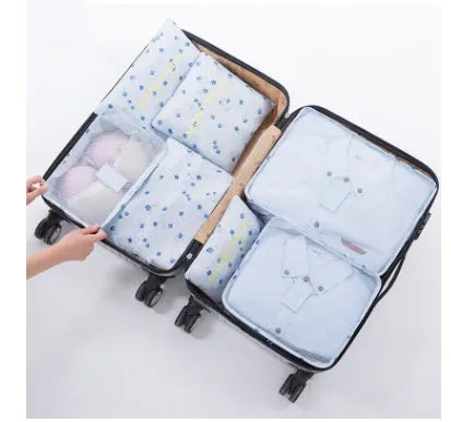 Set of six coloured nylon packing cubes and flat pouches for travel organisation.