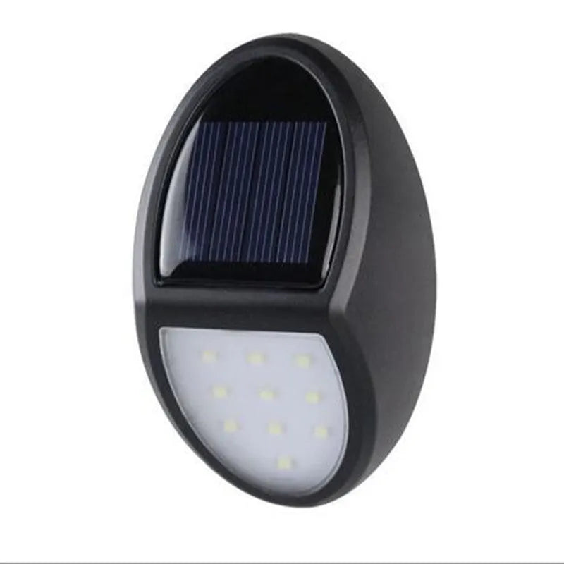 Black rectangular LED solar wall light mounted on an outdoor wall with a visible solar panel.