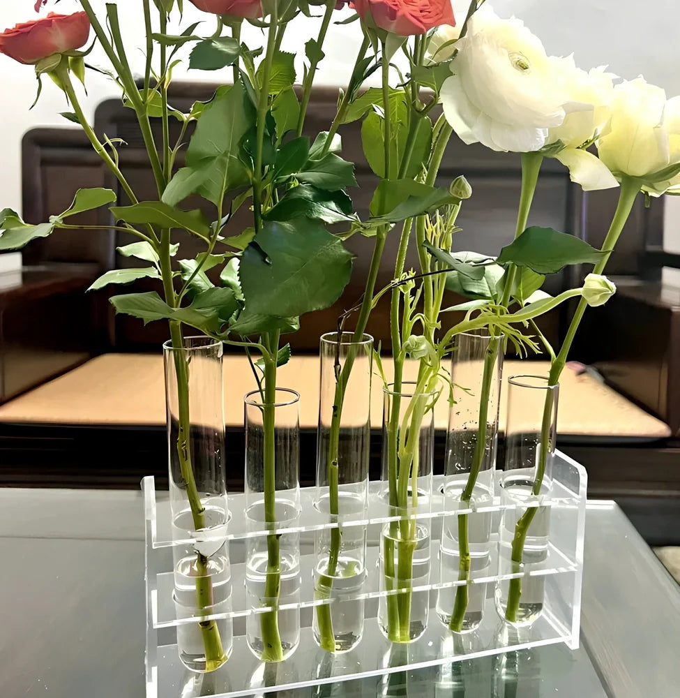 Clear glass hinged test tube vase with plants in curved arrangement