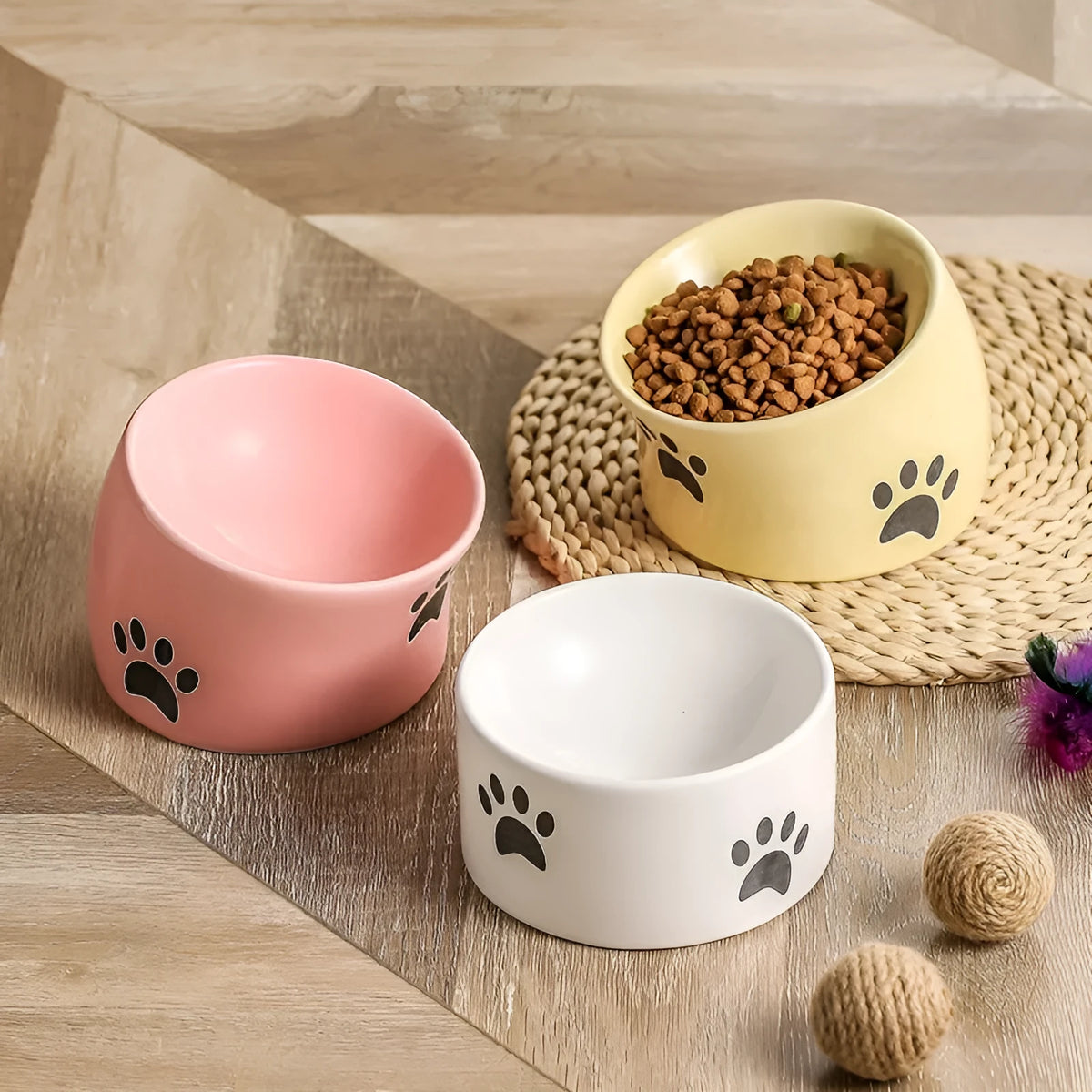 Ceramic cat bowl with high foot and cat's paw base in an oblique mouth design.