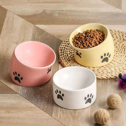 Ceramic cat bowl with high foot and cat's paw base in an oblique mouth design.