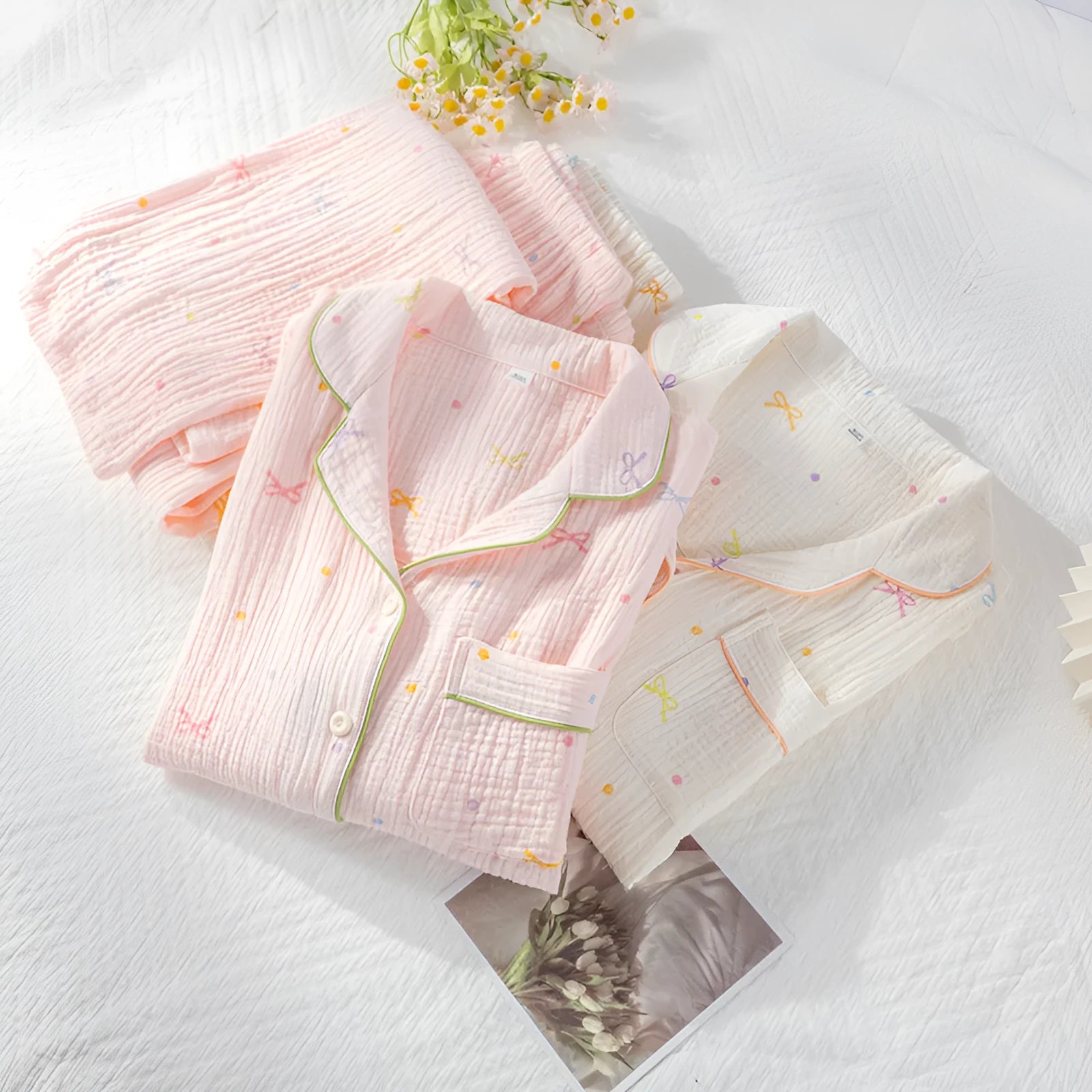 Women's pink cotton long sleeve pajama set with trousers on a hanger.