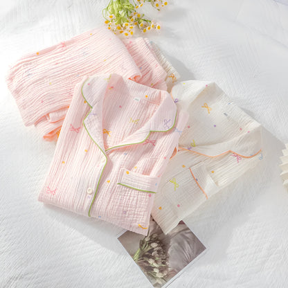 Women's pink cotton long sleeve pajama set with trousers on a hanger.