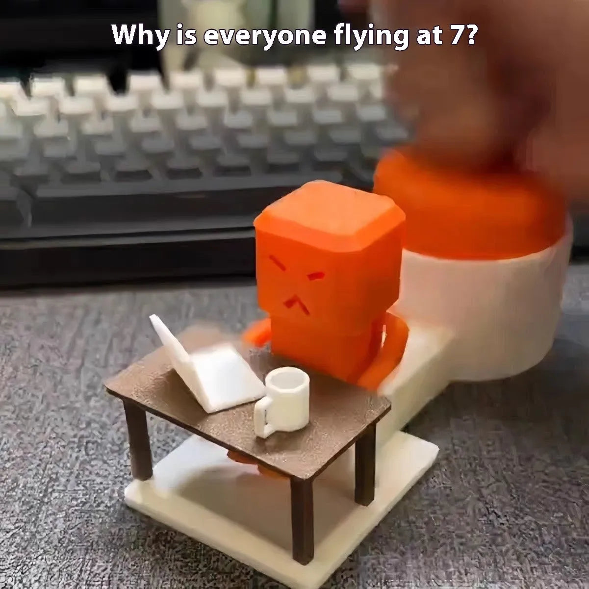Orange plastic vent decompression toy with turning table mechanism on a desk.