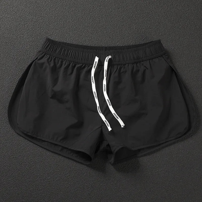 Men's loose orange beach shorts with elastic waist on a sandy shore