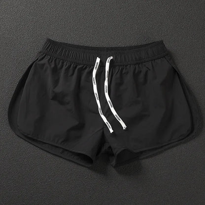 Men's loose orange beach shorts with elastic waist on a sandy shore