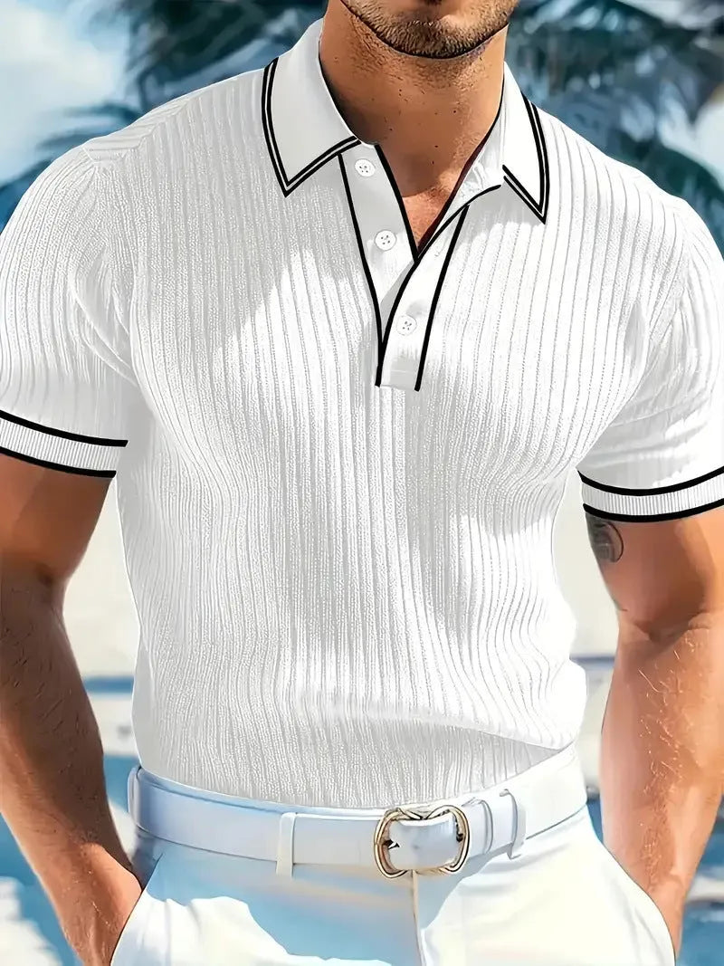 A man wearing a loose-fit, striped, short-sleeved polo shirt in a dark colour.