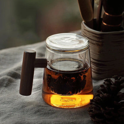 Premium glass tea infuser cup with wooden handle, offering a unique tea-water separation system and temperature-resistant construction for a refined tea experience.