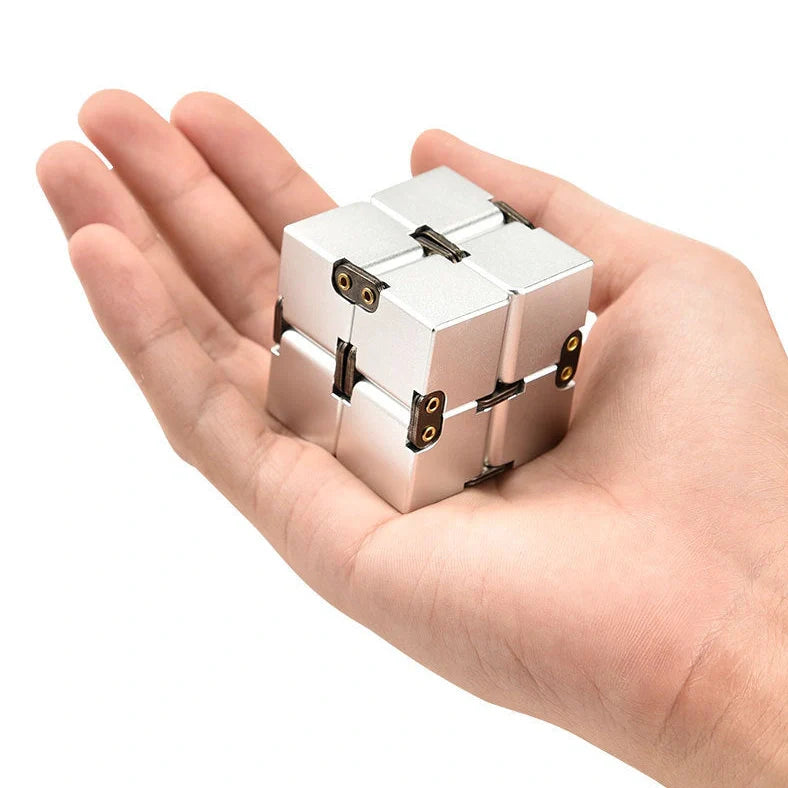 Zinc alloy Infinity Cube with eight rotating cubes showing black and silver colour options on wooden surface