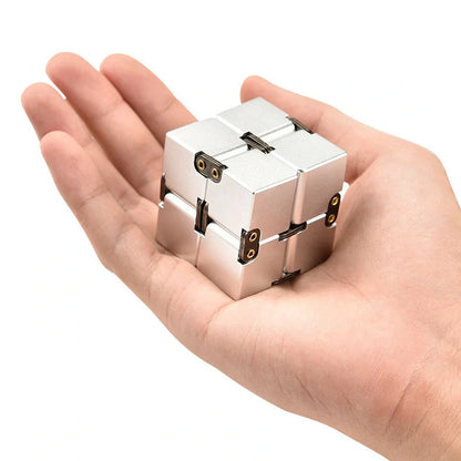 Zinc alloy Infinity Cube with eight rotating cubes showing black and silver colour options on wooden surface