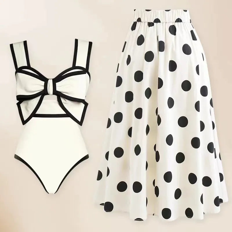 Women's black one-piece swimsuit with white skirt and bow detail for beach swimming