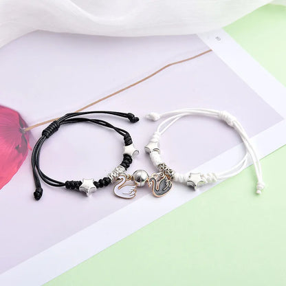 Magnetic suction couple bracelet pair in alloy with an electroplated finish, showing example designs like a crown and love lock.