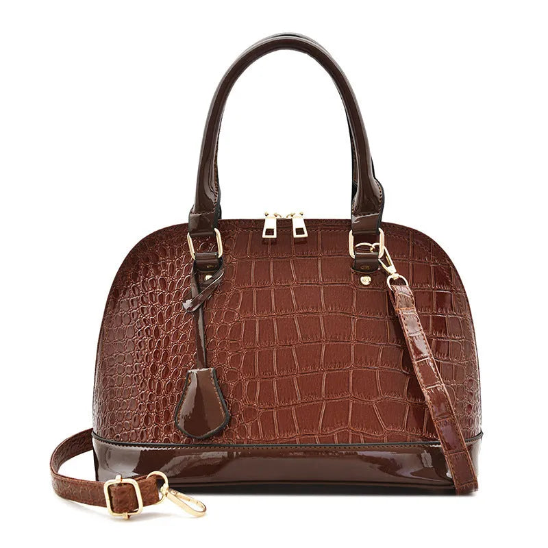 Shiny black PU leather crossbody bag with a structured shell shape and a long strap.
