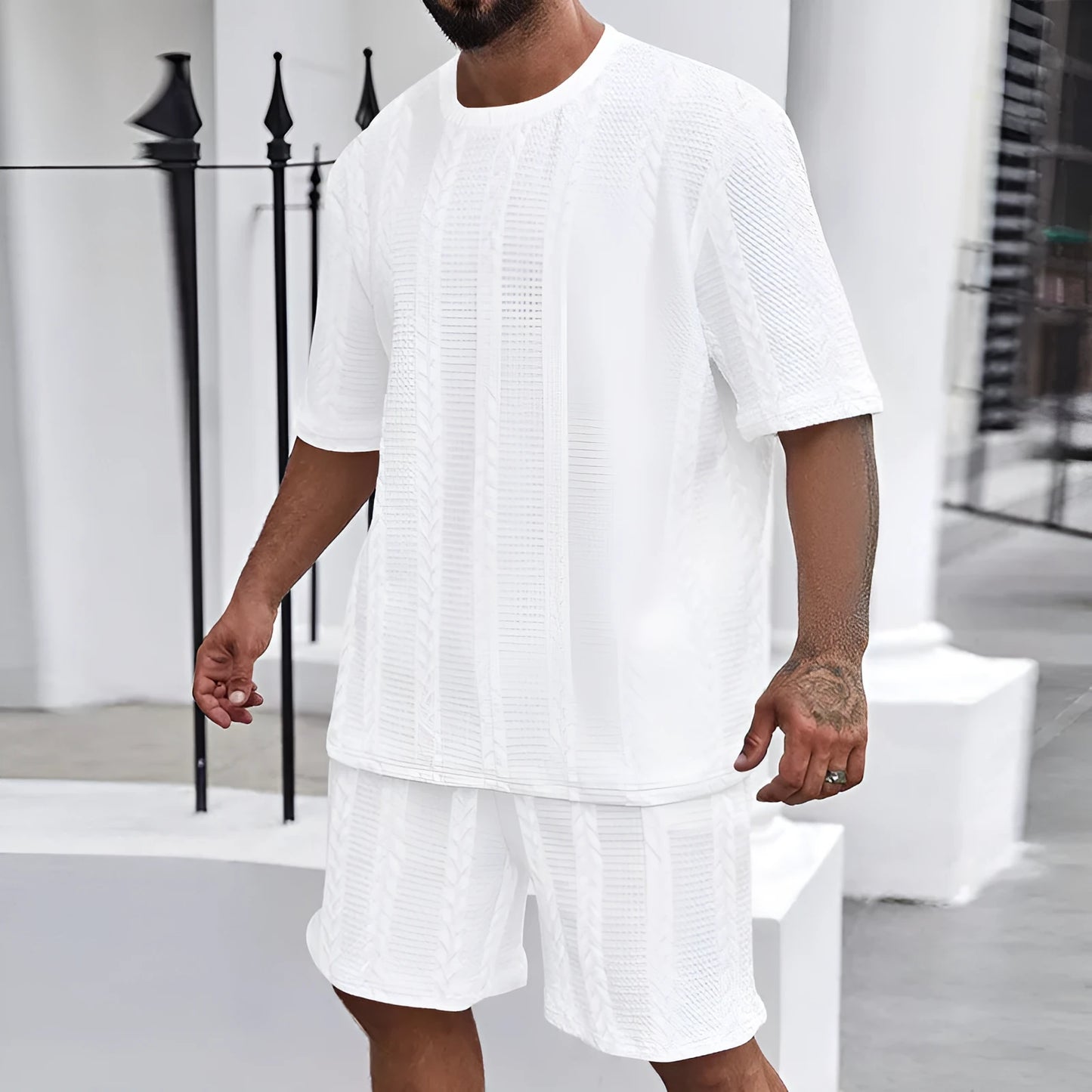 Knitted short-sleeve pullover and matching shorts set in light grey, laid flat.