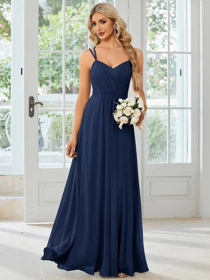 Women's sleeveless long dress with sling neckline and pleated A-line skirt in a solid colour.
