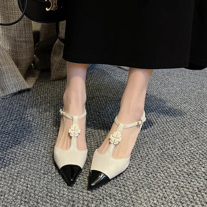Women's black pointed toe stiletto heel shoes with floral buckle on sheepskin upper.