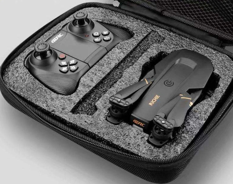 Black folding drone with 4K camera, protective frames, and remote control on grey background