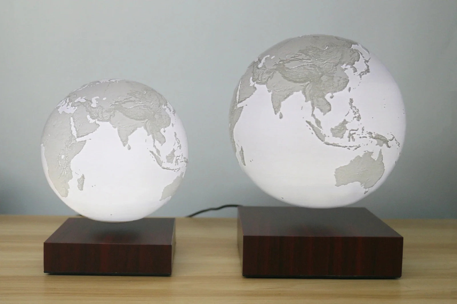 Levitating Earth or Jupiter lamp floating above base with LED illumination