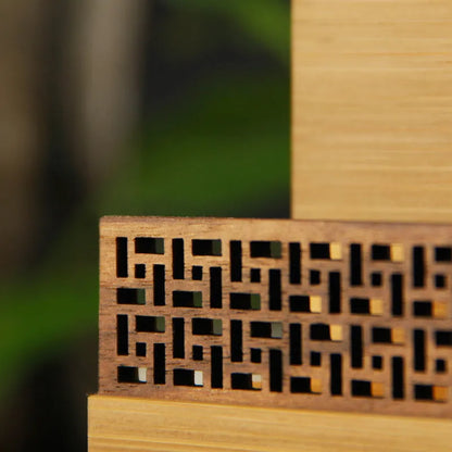 Geometric bamboo and black walnut wood business card holder on a desk.