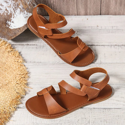 Women's black velcro flat sandals with round toe and rubber sole on a white background