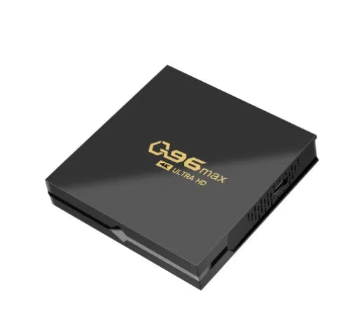 Q96 MAX Android TV set-top box with remote control and HDMI cable on a wooden surface.