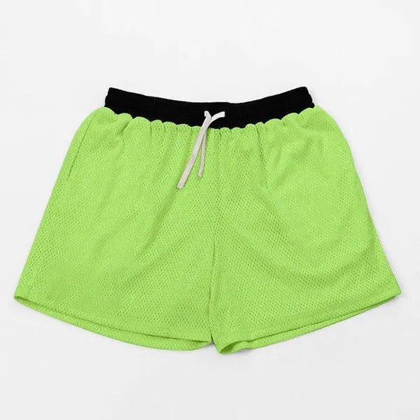 Men's black athletic shorts with grey mesh side panels for breathability, laid flat on a surface.