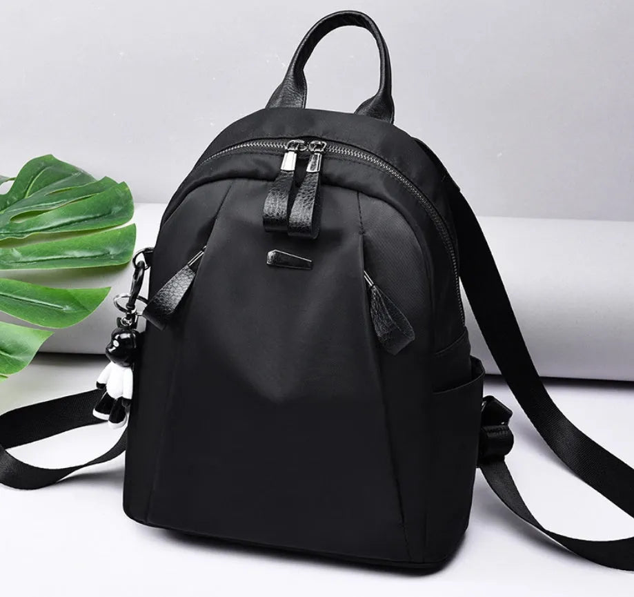 Medium square rucksack in Oxford cloth with two straps and a soft handle, shown in wine red.