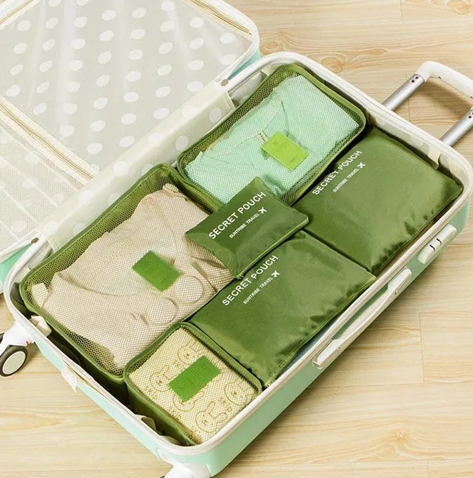 Set of six coloured nylon packing cubes and flat pouches for travel organisation.