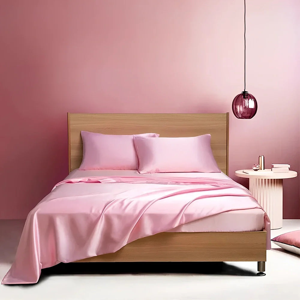 Navy blue floral pattern silk bedding set with quilt cover, fitted sheet, and two pillowcases on bed