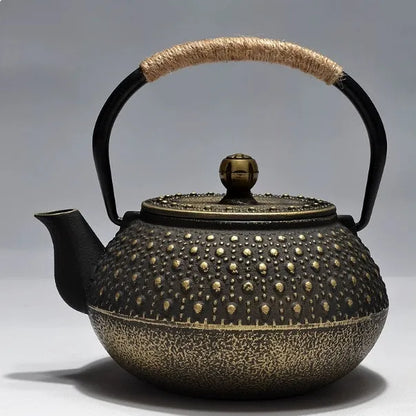 Japanese-style cast iron teapot with lid on a hob, shown in a bronze finish.