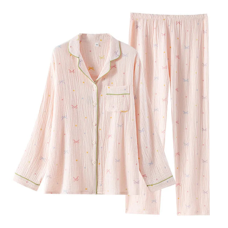 Women's pink cotton long sleeve pajama set with trousers on a hanger.