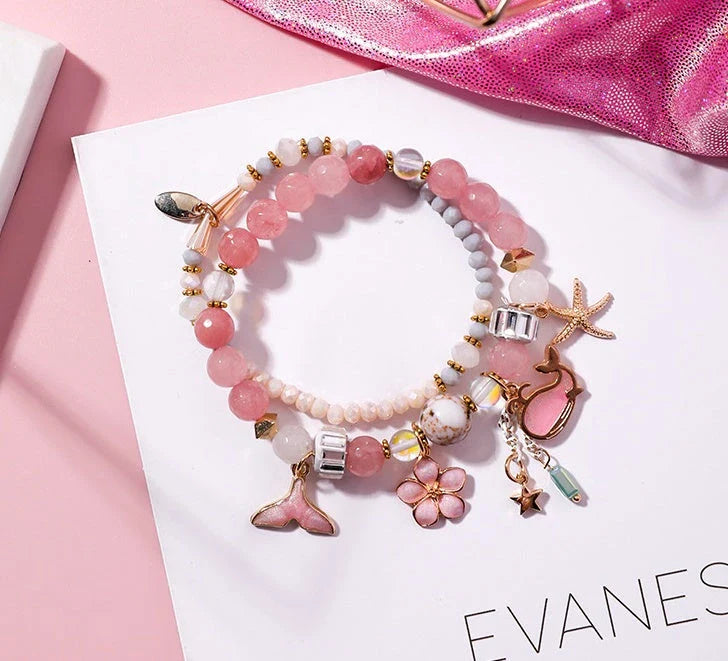 Elegant whale tail bracelet in vibrant colors with flower and starfish accents, perfect for adding a touch of coastal charm to any outfit.
