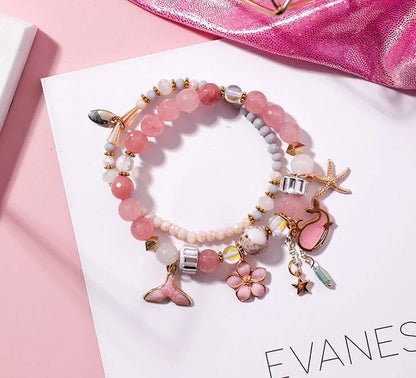 Elegant whale tail bracelet in vibrant colors with flower and starfish accents, perfect for adding a touch of coastal charm to any outfit.