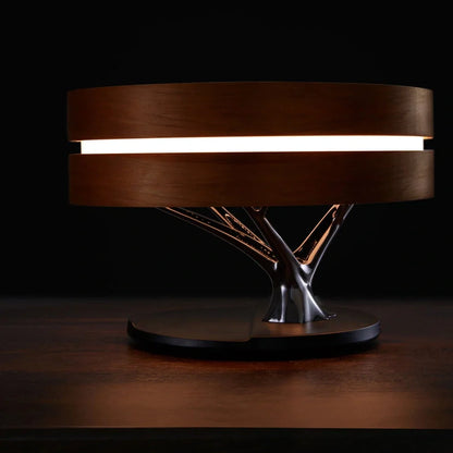 Round Bluetooth speaker with LED tree lighting and wireless charging surface in maple brown finish