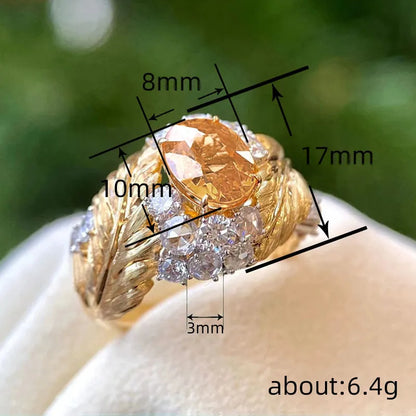 Gold colour copper ring with embossed feather pattern and inlaid yellow zircon, showing geometric shape and detailed texture