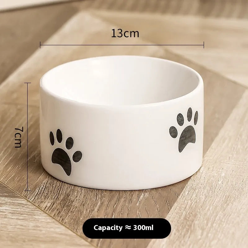 Ceramic cat bowl with high foot and cat's paw base in an oblique mouth design.